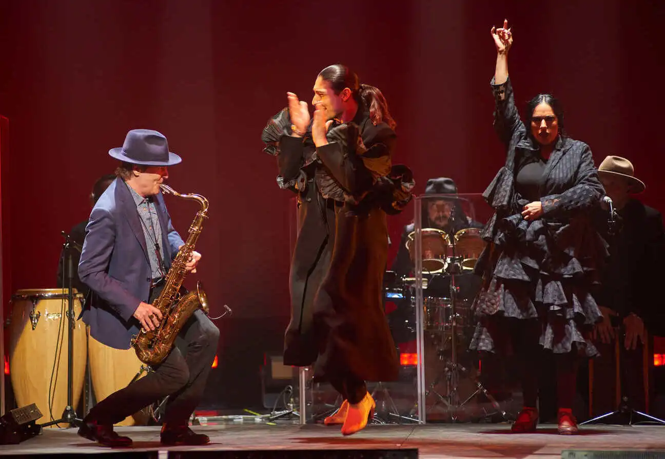 Espectáculo de flamenco en Madrid con una fusión de saxofón y baile tradicional. Bailaora y bailaor en un escenario con músicos en vivo, creando una atmósfera apasionada y enérgica