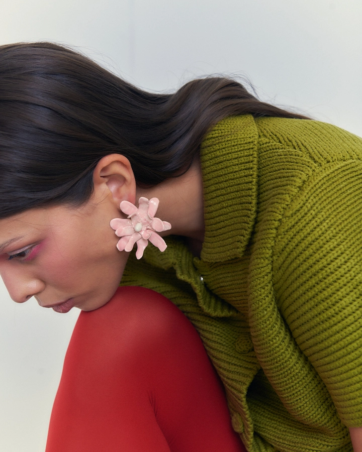 Una mujer con pendientes de flor grandes de la nueva colección de joyería artesana de Julieta Álvarez